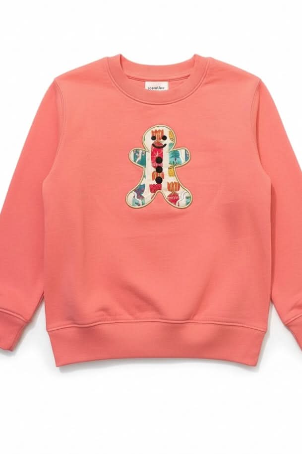 Coral sweatshirt with a colorful gingerbread man design on a white background